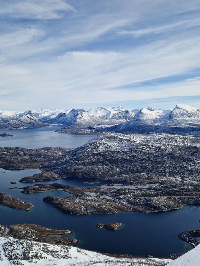 Stunning aerial photograph showcasing the snowy peaks and coastal landscape of Norway.