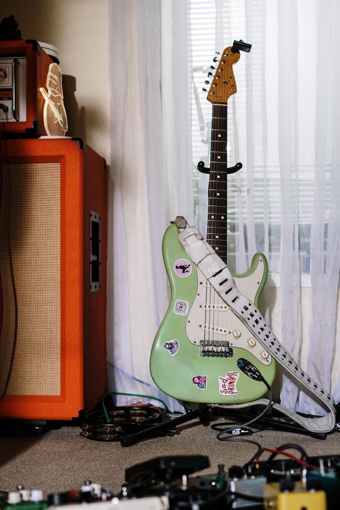 ours-journey Stylish electric guitar with amp and equipment in a cozy home studio setting.